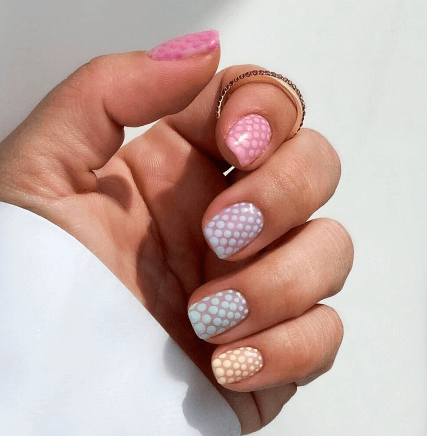 Mano femenina con manicura en tonos rosados y diseño delicado. belleza y bienestar natural en Bela Estética Carcaixent